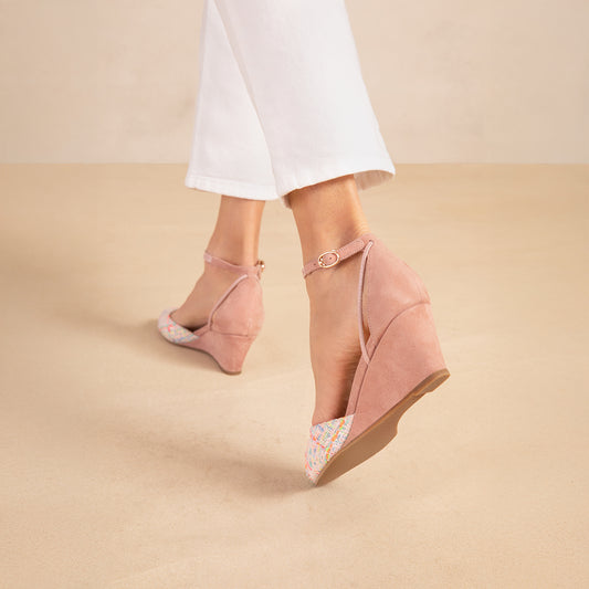 A woman's foot in a pink wedge heel