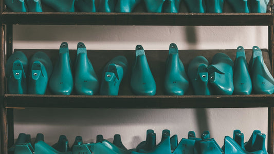 Rows of standardized shoe lasts used in footwear manufacturing, illustrating fashion industry production standards.
